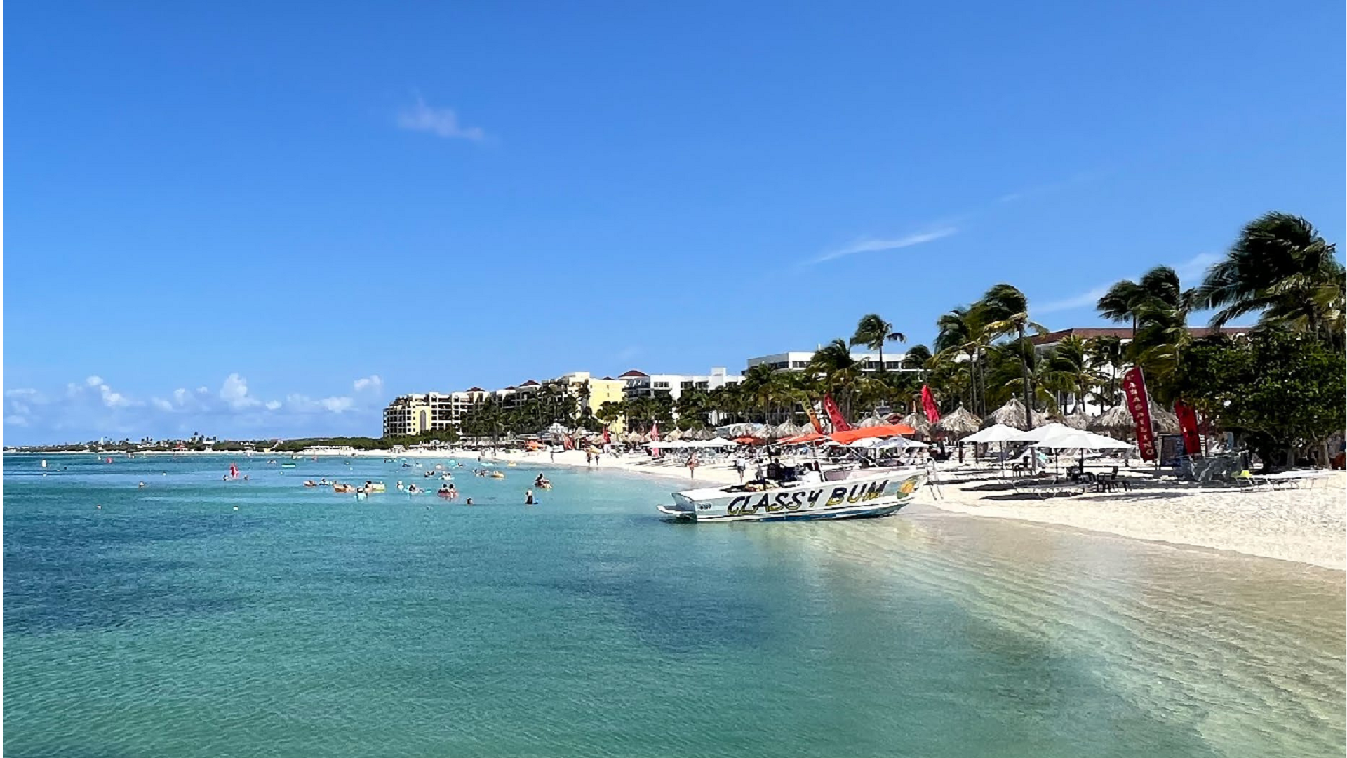 Palm Beach Aruba with tourists swimming and beachfront resorts showing coastal tourism infrastructure
