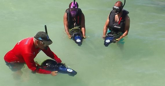 Guide demonstrating how to use sea scooters in shallow Caribbean water